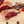 Load image into Gallery viewer, A close up picture of il porcellino salumi's duck prosciutto. The duck prosciutto is cut into slices on a cutting board with whole chubs and spices in the background.
