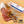 Load image into Gallery viewer, A picture of il porcellino salumi's Spiced Juniper Salami on a cutting board with herbs and spices shot from above. Once piece of salami is cut into slices while the other remains in packaging. Plus the Charcuterie Masters Grand Champion logo is placed in the lower right corner of the image.

