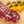 Load image into Gallery viewer, A close up of slices of hard salami with pistachios, fat, herbs and spices in it. The salami is on a cutting board with blurred pistachios and orange zest in the background.
